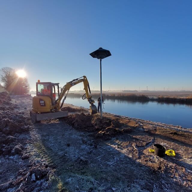 Gierzwaluwtil - 2 Afbeelding van een til voor zwaluwen die geplaatst wordt door werknemers langs een kanaal