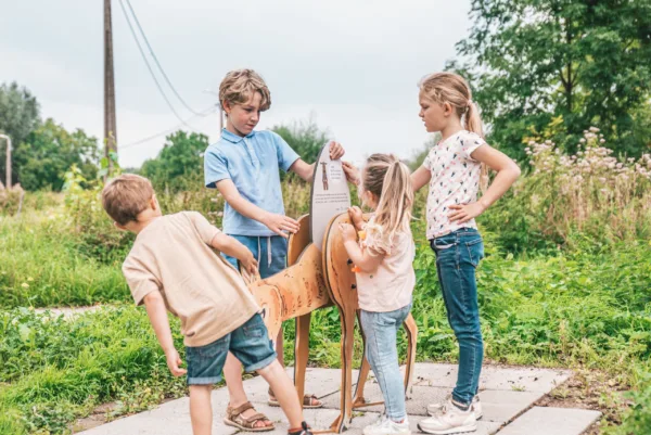 Afbeelding van een aantal kinderen die een informatiebord lezen op een belevingspad.