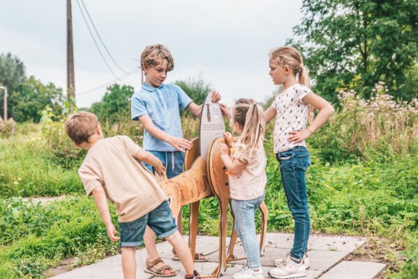 Afbeelding van een aantal kinderen die een informatiebord lezen op een belevingspad.